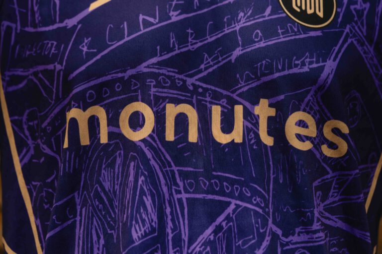 Close-up van de naam van Team Monutes op de borst van het zaalvoetbaltenue