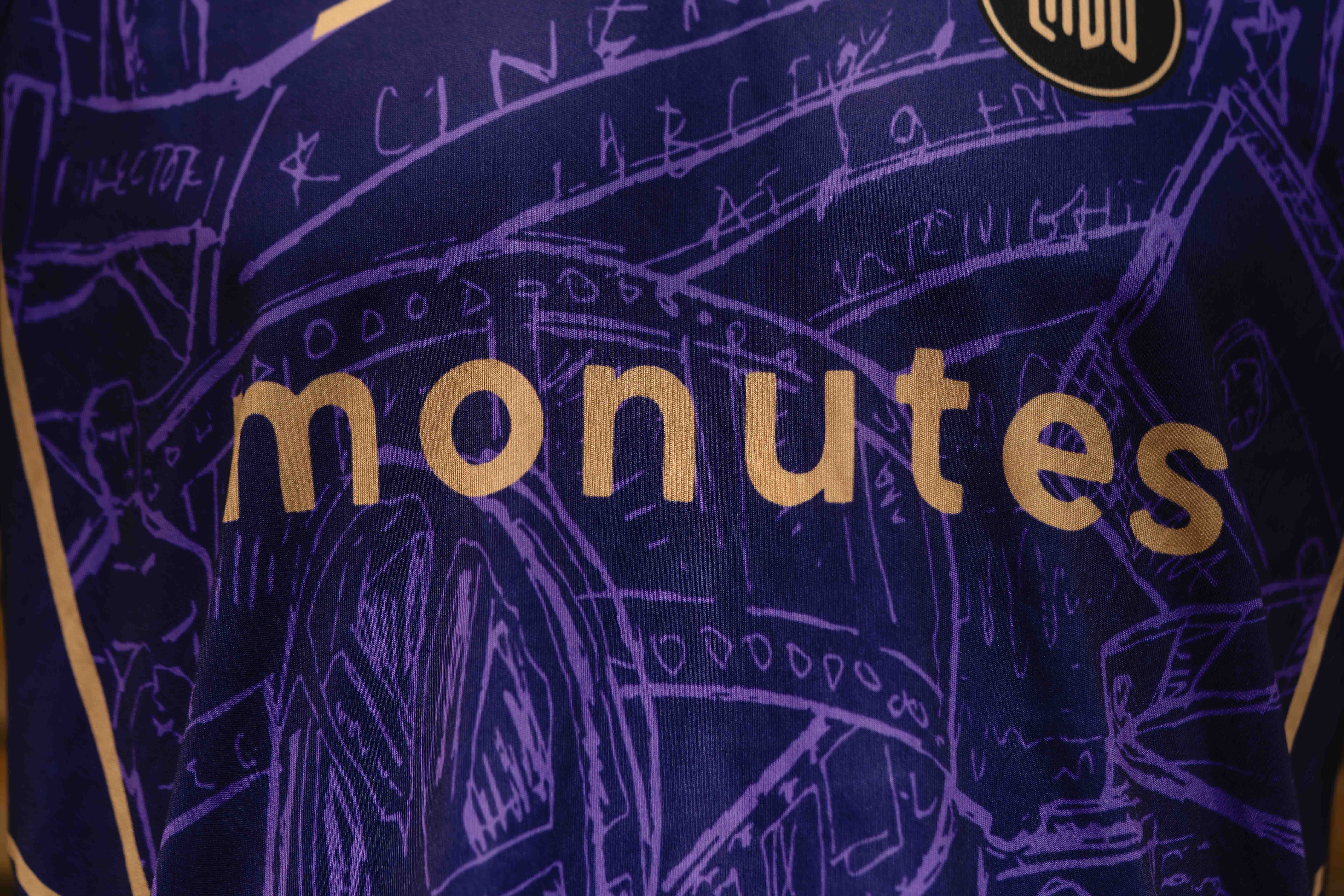 Close-up van de naam van Team Monutes op de borst van het zaalvoetbaltenue