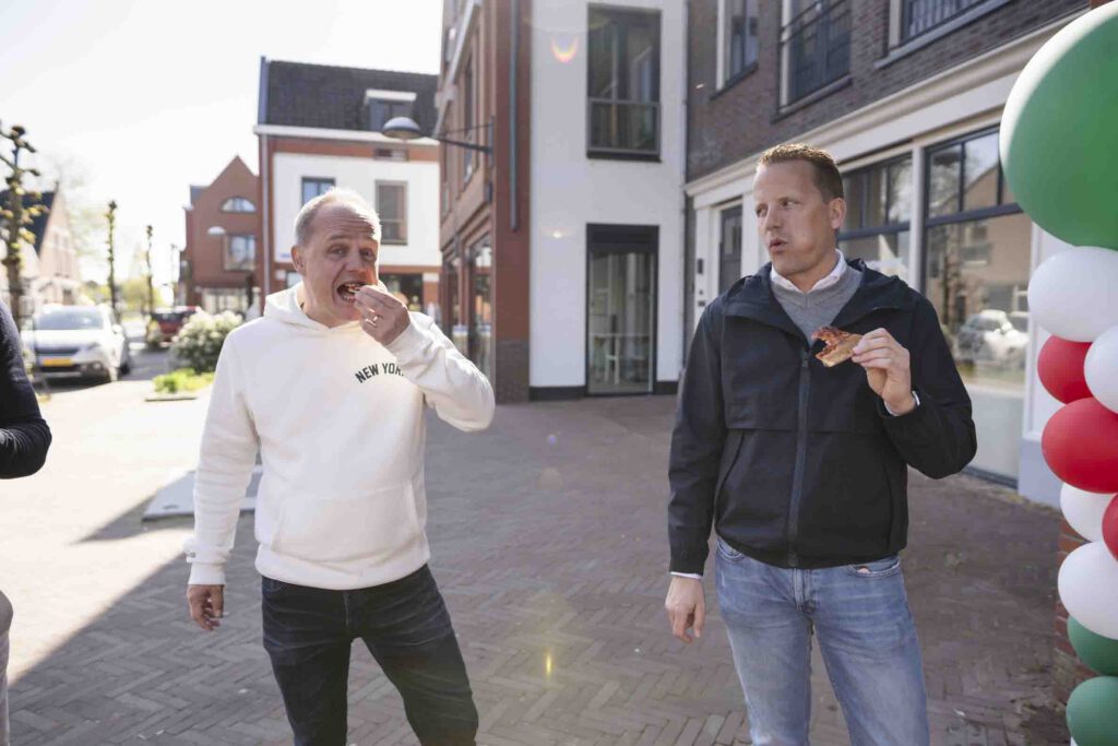 Twee personen in gesprek buiten bij New York Pizza Nieuwkoop tijdens de openingsdag